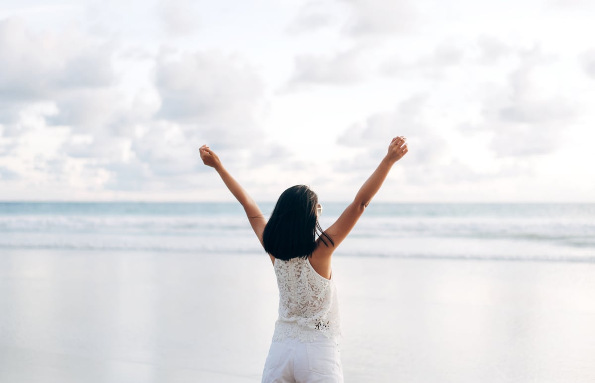 Woman Stretching Hand and Open Arms at the Beach